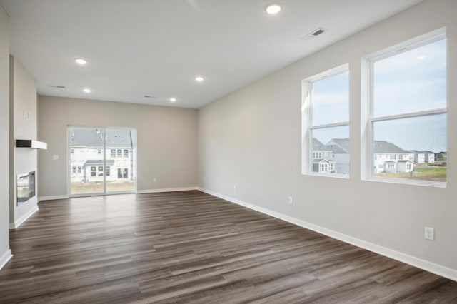 spare room featuring dark wood-style floors, recessed lighting, visible vents, and baseboards