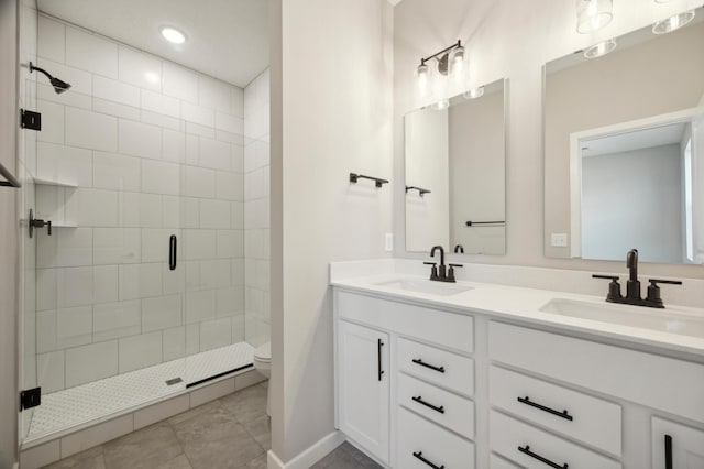 full bathroom with double vanity, a sink, toilet, and a shower stall