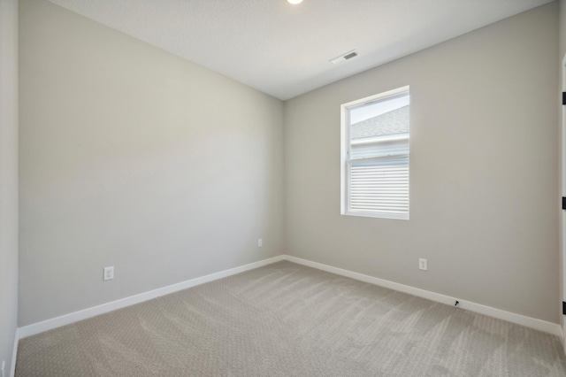 unfurnished room featuring light carpet, visible vents, and baseboards