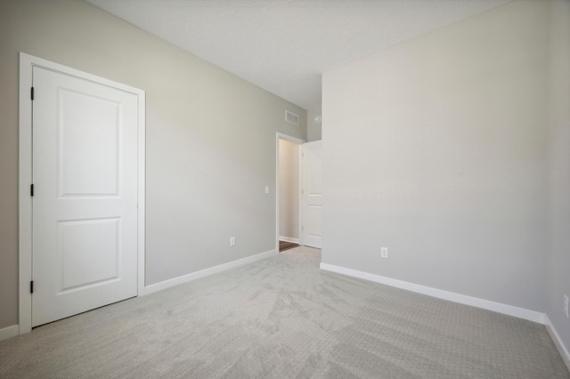 unfurnished room featuring baseboards, visible vents, and carpet flooring