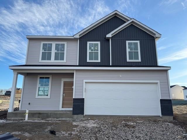 view of front of property with a garage, dirt driveway, and board and batten siding