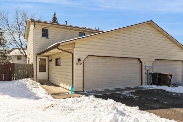 exterior space featuring a garage and fence