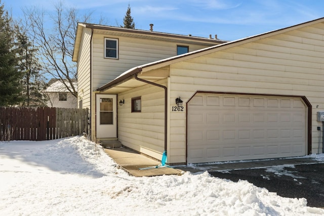 exterior space with fence and an attached garage