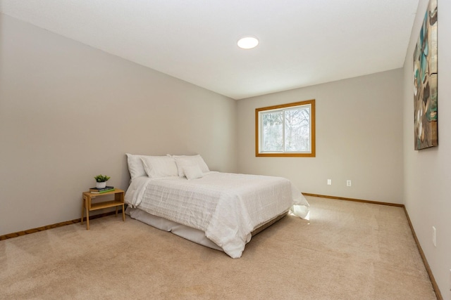 bedroom featuring baseboards and light colored carpet