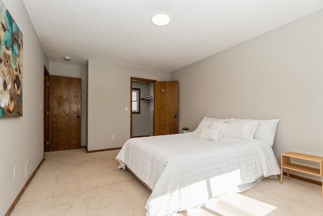 bedroom with baseboards, visible vents, and light colored carpet