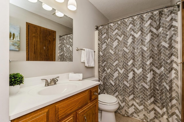 bathroom with a textured ceiling, curtained shower, tile patterned flooring, toilet, and vanity