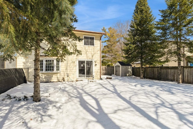 back of property with a fenced backyard, an outdoor structure, and a shed