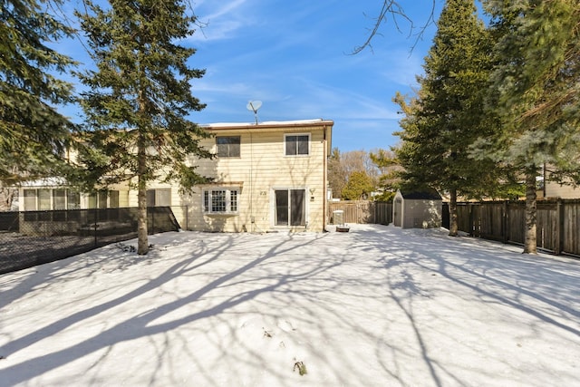 back of house with an outbuilding, a storage shed, and a fenced backyard