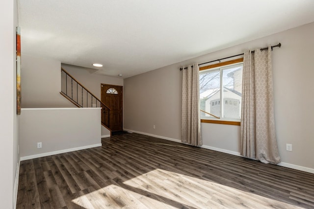 spare room with stairway, baseboards, and wood finished floors