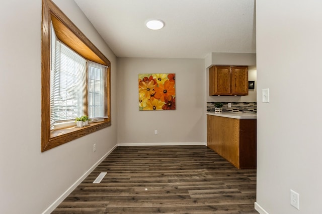 dining room featuring dark wood-style floors, visible vents, and baseboards