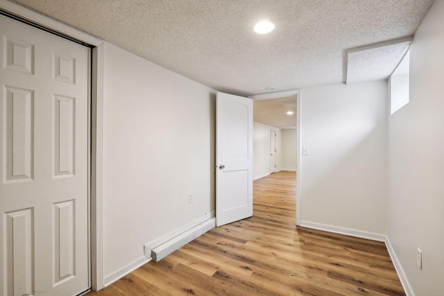 unfurnished room featuring baseboards, recessed lighting, a textured ceiling, and light wood-style floors