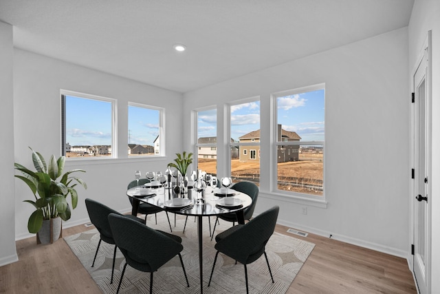 dining room featuring light wood-type flooring, visible vents, baseboards, and recessed lighting