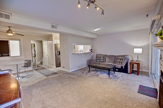 carpeted living room featuring a wealth of natural light, visible vents, and crown molding