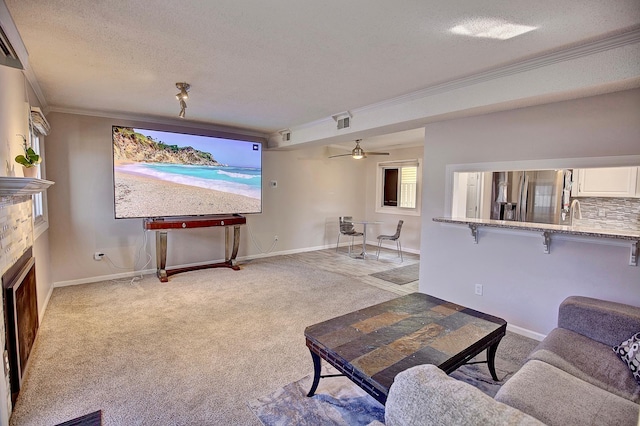 living room featuring visible vents, ornamental molding, a textured ceiling, a fireplace, and light colored carpet