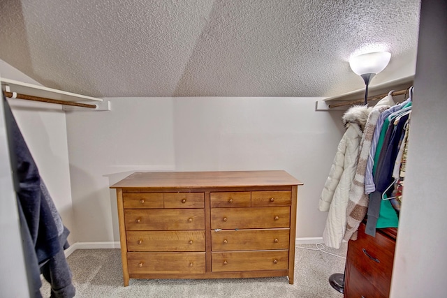 spacious closet featuring vaulted ceiling and light carpet