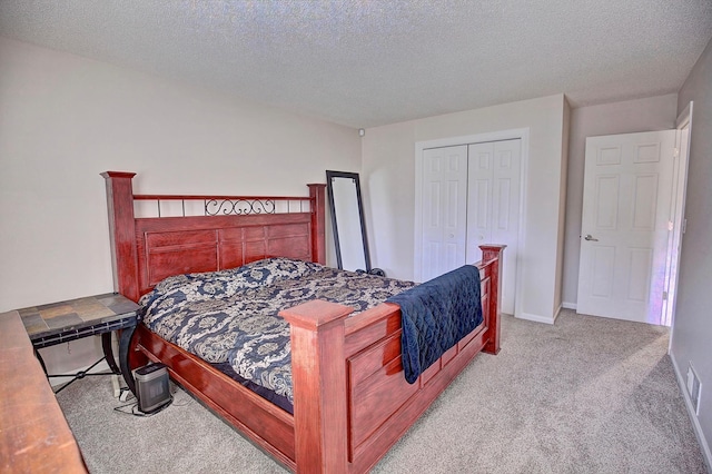 bedroom with baseboards, a closet, carpet floors, and a textured ceiling