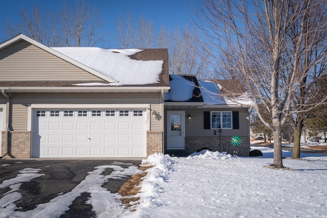 view of front facade with brick siding, driveway, and an attached garage