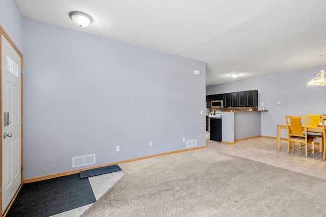 living room featuring visible vents, baseboards, and light colored carpet