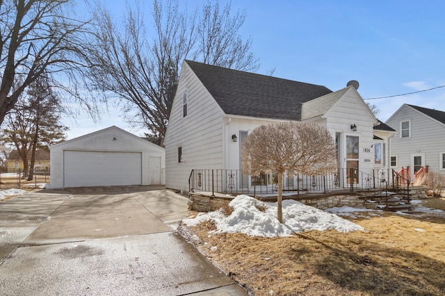 view of front of home featuring an outdoor structure, a detached garage, and a shingled roof