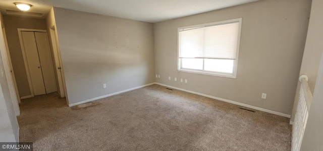 unfurnished bedroom with visible vents, baseboards, and carpet flooring