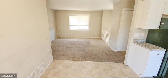 unfurnished room with baseboards, light carpet, and visible vents