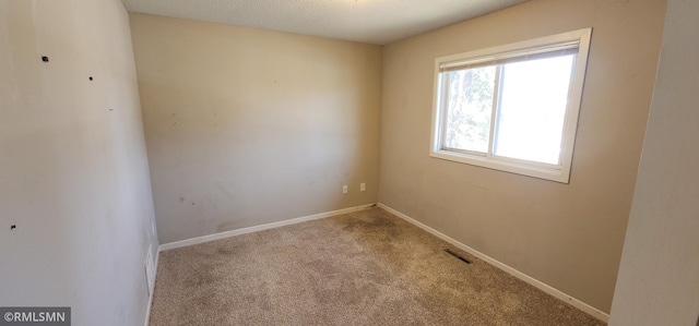 unfurnished room featuring visible vents, baseboards, and carpet flooring