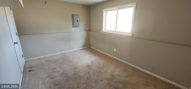 carpeted spare room with electric panel and baseboards