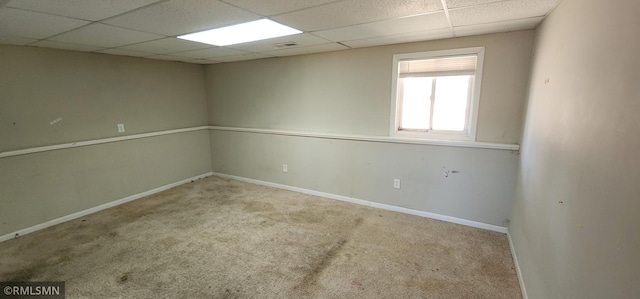 carpeted empty room featuring visible vents, a paneled ceiling, and baseboards