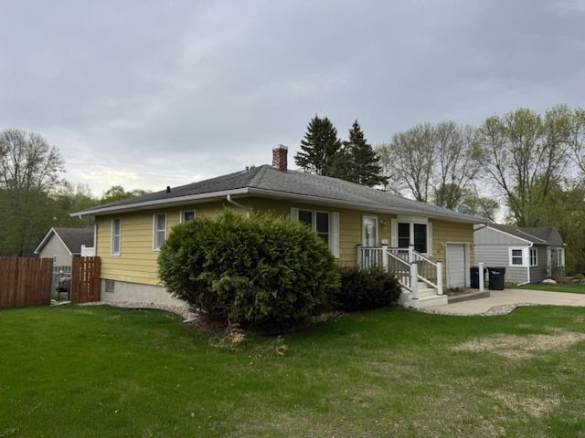 ranch-style home featuring a chimney, an attached garage, and driveway