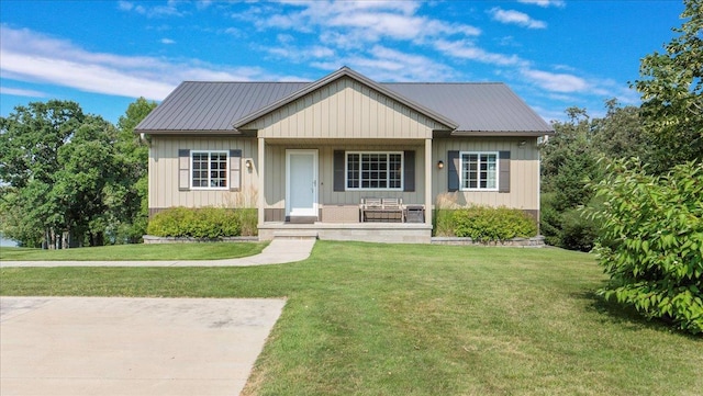 view of front of home with a porch, metal roof, and a front yard