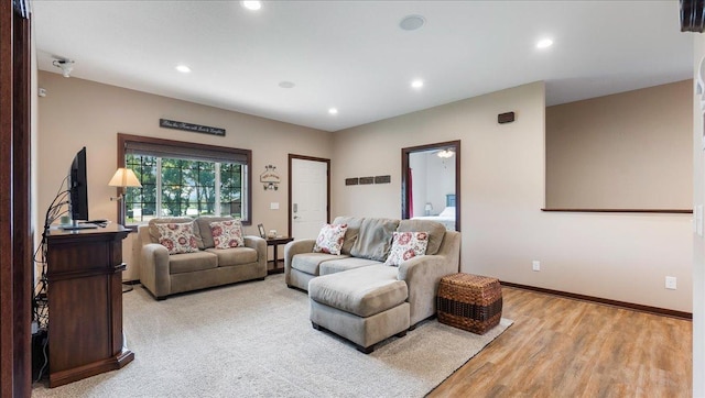 living room with light wood-style floors, recessed lighting, and baseboards