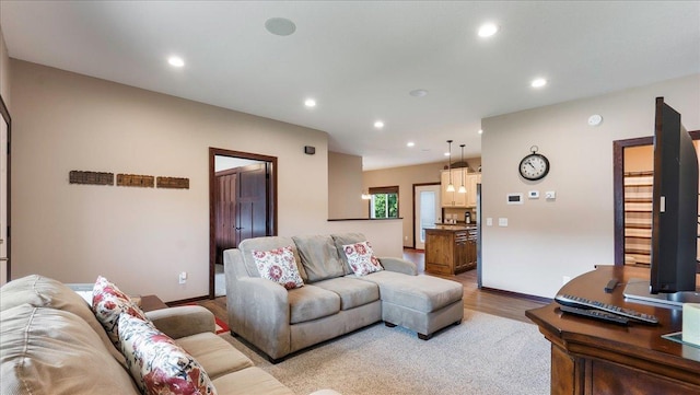 living area with recessed lighting, baseboards, and wood finished floors