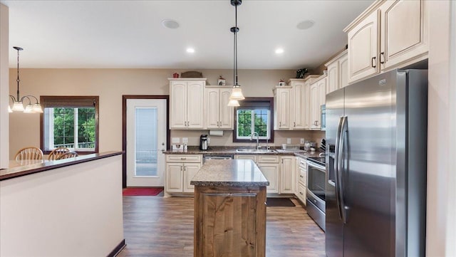 kitchen featuring a sink, dark wood-type flooring, appliances with stainless steel finishes, and a center island