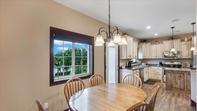 dining space featuring recessed lighting, an inviting chandelier, and wood finished floors