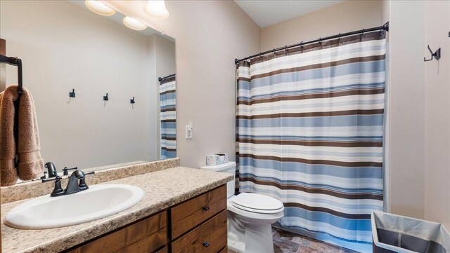 full bathroom featuring curtained shower, toilet, and vanity