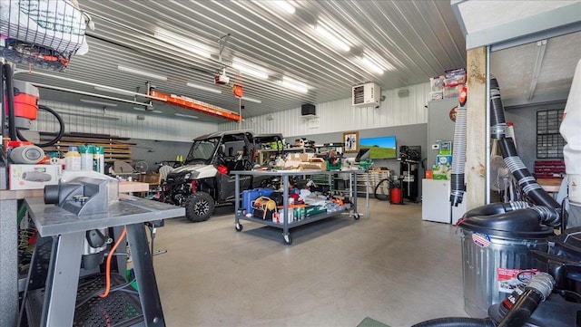 garage featuring a workshop area, a garage door opener, and metal wall