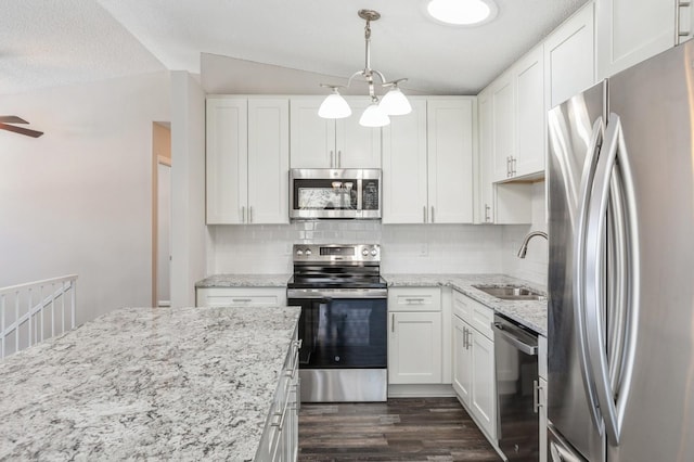 kitchen featuring lofted ceiling, dark wood-style flooring, a sink, white cabinets, and appliances with stainless steel finishes