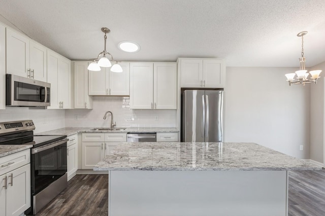 kitchen with dark wood-style floors, tasteful backsplash, appliances with stainless steel finishes, and a sink
