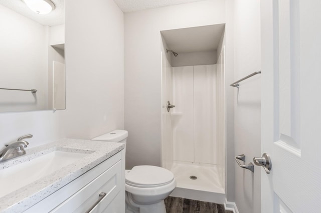 full bathroom with toilet, a shower stall, wood finished floors, and vanity