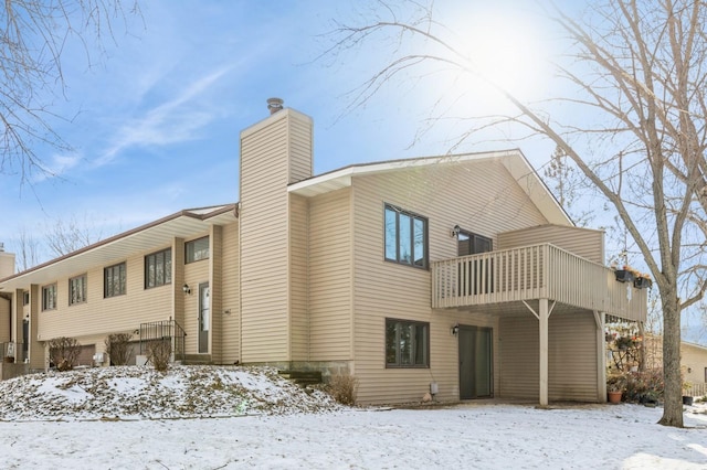 snow covered property with a chimney