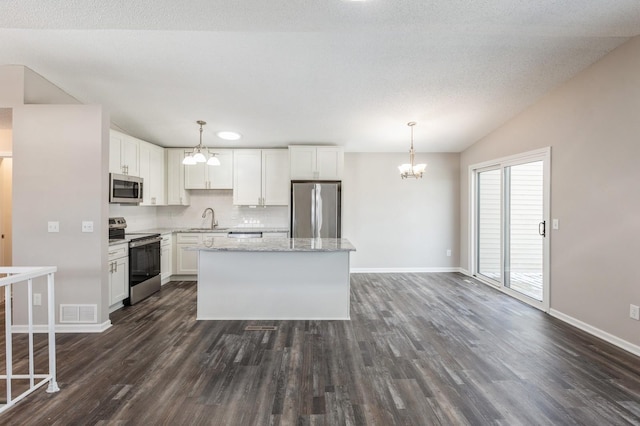 kitchen with visible vents, an inviting chandelier, stainless steel appliances, white cabinetry, and a sink