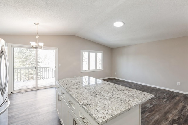 kitchen with light stone counters, lofted ceiling, dark wood finished floors, and baseboards