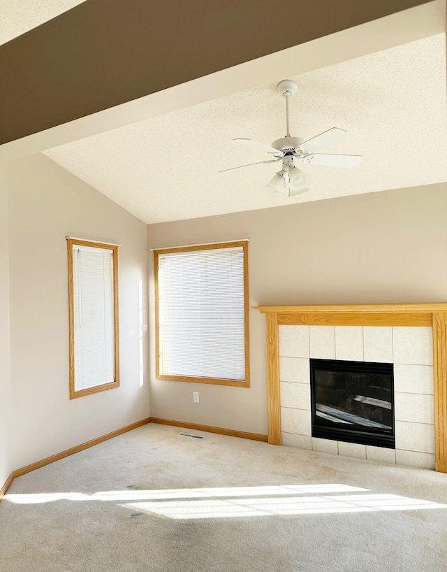 unfurnished living room featuring visible vents, a tile fireplace, baseboards, and lofted ceiling