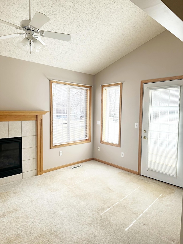 unfurnished living room with a wealth of natural light, carpet, and vaulted ceiling