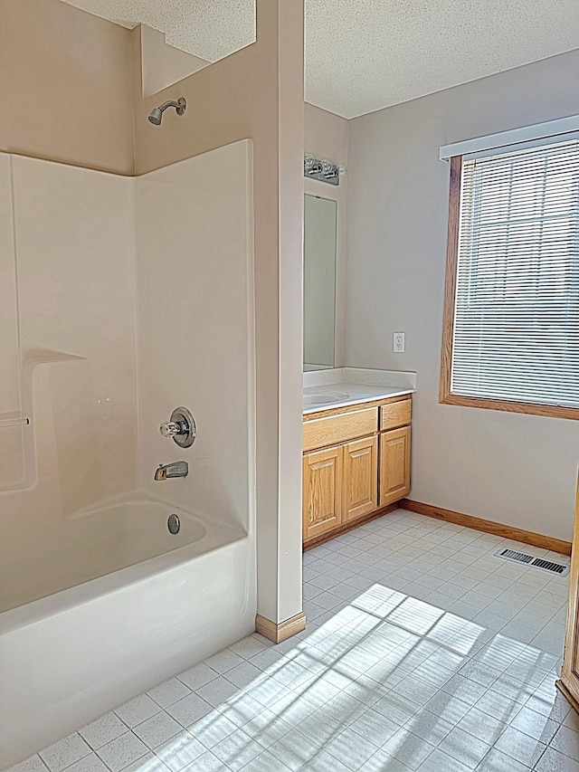 full bath featuring visible vents, baseboards, bathing tub / shower combination, a textured ceiling, and vanity