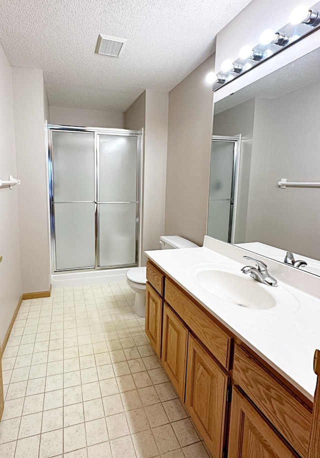 full bathroom with visible vents, toilet, a stall shower, a textured ceiling, and vanity