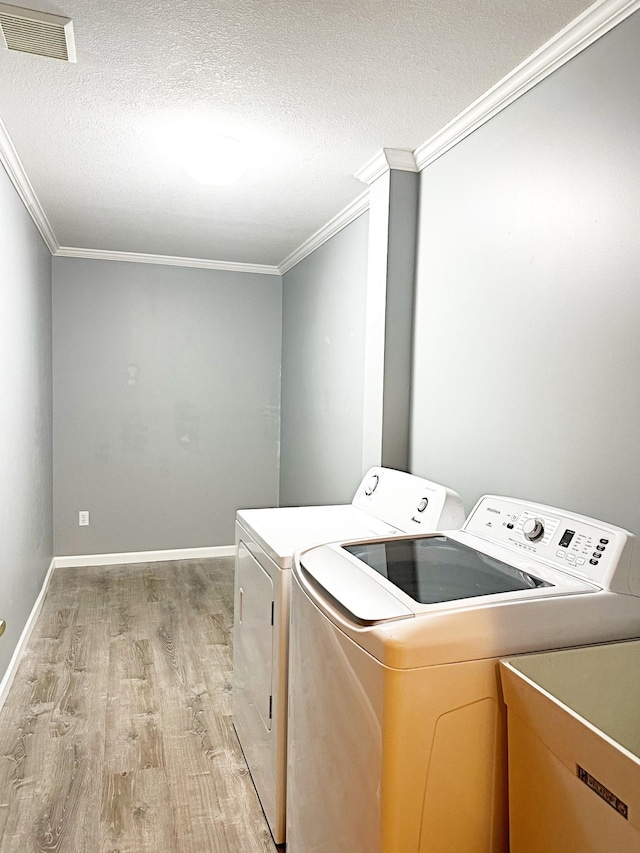 laundry room featuring visible vents, laundry area, light wood-style flooring, a textured ceiling, and washing machine and dryer