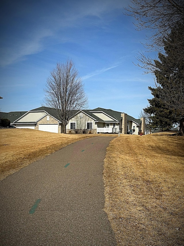 view of front of house featuring aphalt driveway and a front lawn