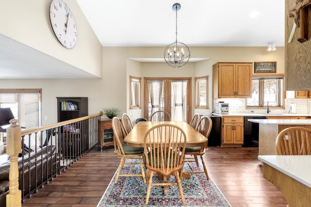 dining area with french doors, dark wood-style flooring, and a notable chandelier