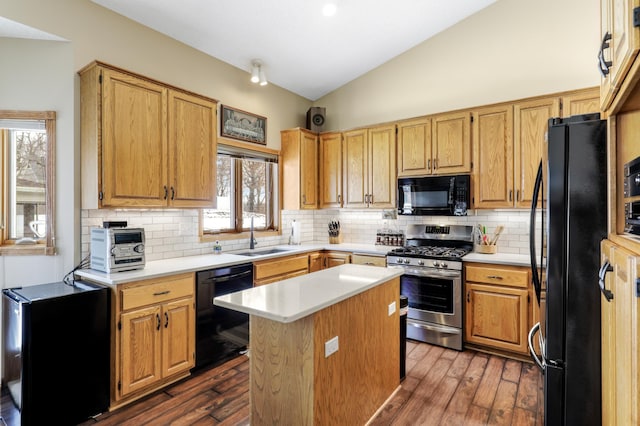 kitchen featuring dark wood-style floors, lofted ceiling, light countertops, a sink, and black appliances